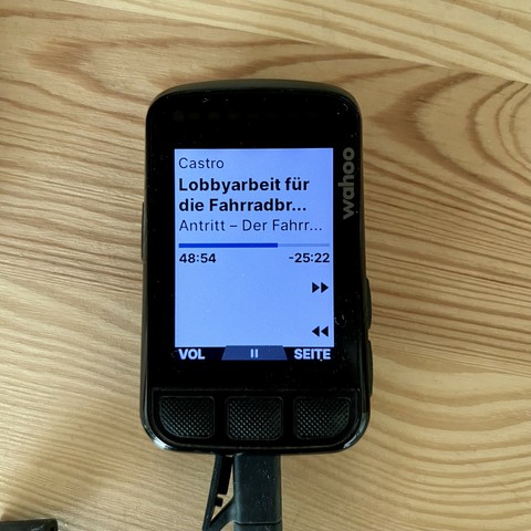 Foto eines Wahoo Elemnt Bolt Fahrradcomputer der die Musiksteuerungsseite anzeigt. 
Es wird angezeigt: die abspielende App, Titel, Interpret, Laufzeit, Restzeit. Man kann skippen, pausieren und die Lautstärke ändern. 