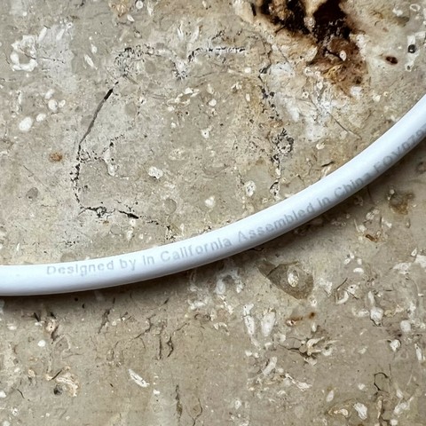 Fake Apple charging cable with “Designed by in California Assembled in China” printed on it. Otherwise it looks like an original Apple charging cable. 