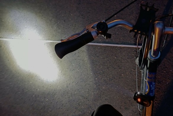 Fahrrad mit Klemmlicht am Rahmen, das seitwärts leuchtet.