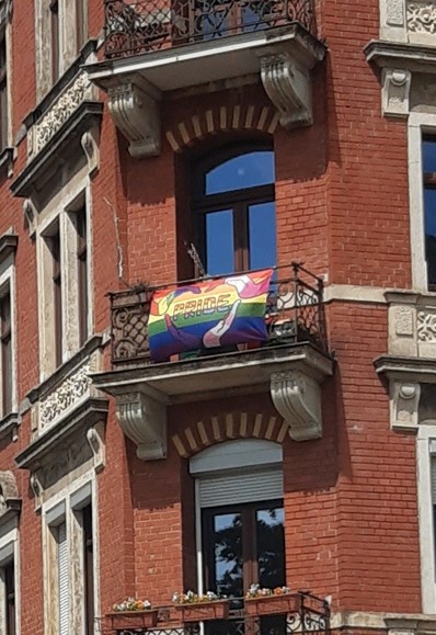 An einem Balkon hängt seit gefühlt immer eine PrideFahne.