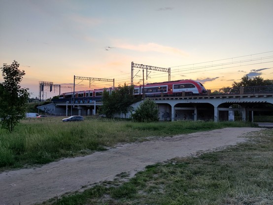 Pesa Elf der Koleje Wielkopolskie auf einer Brücke bei Sonnenuntergang 